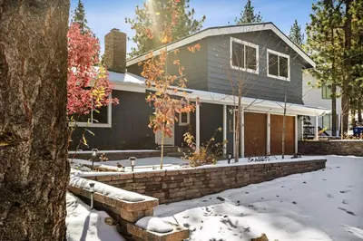 a house in the snow with a brick wall at Lakeside Paradise Escape in Big Bear Lake