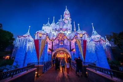 a group of people walking in front of a disney castle at 2 Miles to Disneyland -FREE Parking! In Anaheim CA in Anaheim