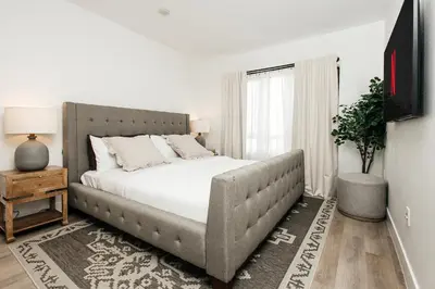 a bedroom with a large bed with white sheets at Central Quality 2 BD Apartment in Los Angeles