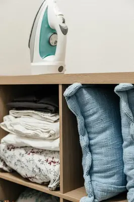 a cupboard with a iron and a pile of clothes at Central Quality 2 BD Apartment in Los Angeles
