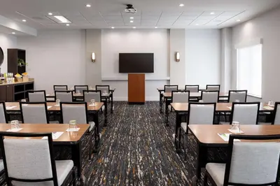a conference room with tables and chairs and a screen at Hyatt Place at Anaheim Resort / Convention Center in Anaheim