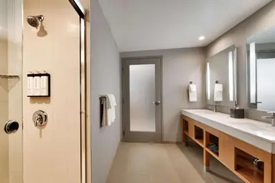 a bathroom with two sinks and a shower at Hyatt Place at Anaheim Resort / Convention Center in Anaheim