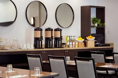 a restaurant with tables and mirrors on the wall at Hyatt Place at Anaheim Resort / Convention Center in Anaheim