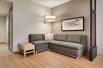 a living room with a gray couch and a table at Hyatt Place at Anaheim Resort / Convention Center in Anaheim