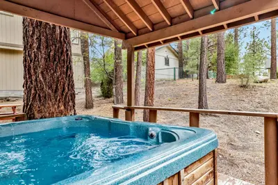 a hot tub on a patio with a tree at Pines and needles #1454 in Big Bear Lake