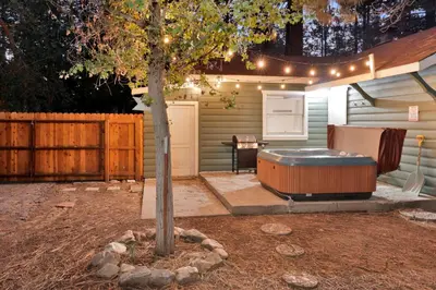 a tree in a yard with a hot tub at Cozy fox #2035 in Big Bear Lake