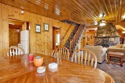 a wooden dining room with a table and a staircase at Pine nest#2296 in Big Bear Lake