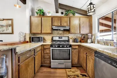 a kitchen with wooden cabinets and a stove top oven at Smith summit chalet #2461 in Big Bear Lake