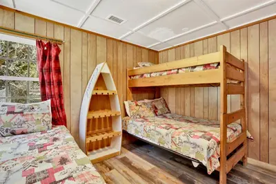 two bunk beds in a room with wooden walls at FRANK'S OLD BEAR #149 in Big Bear Lake