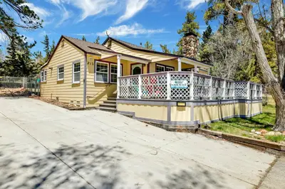 a yellow house with a large deck on a driveway at FRANK'S OLD BEAR #149 in Big Bear Lake