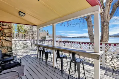 a table and chairs on a deck with a view of the water at FRANK'S OLD BEAR #149 in Big Bear Lake
