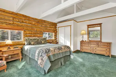 a bedroom with a bed and a wooden wall at Pleasant Pause#1864 in Fawnskin
