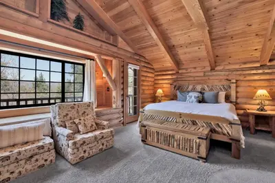 a bedroom in a log cabin with a bed and a chair at Woodland log #1887 in Big Bear Lake