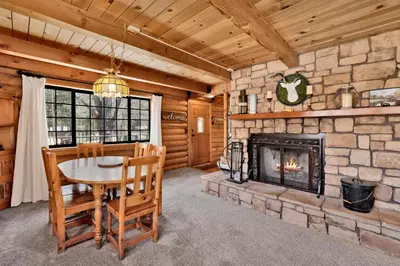 a dining room with a fireplace in a log cabin at Woodland log #1887 in Big Bear Lake