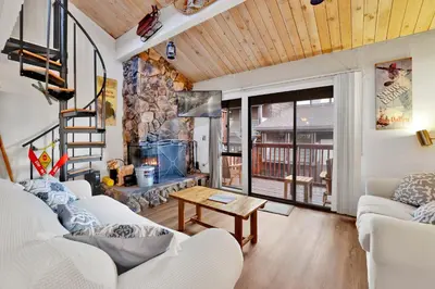 a living room with white couches and a stone fireplace at Chairlift lodge#2354 in Big Bear Lake