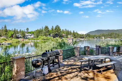 a grill and picnic tables in front of a lake at Breezy one #112 in Big Bear Lake