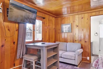 a living room with a table and a chair and a tv at Big pines #103 in Big Bear Lake