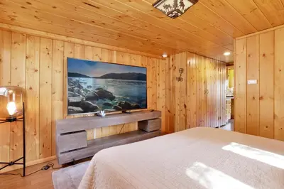 a bedroom with a bed and a tv on the wall at Fawnskin pines #2259 in Fawnskin