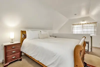 a bedroom with a large white bed and a chair at The weekender #2342 in Big Bear City