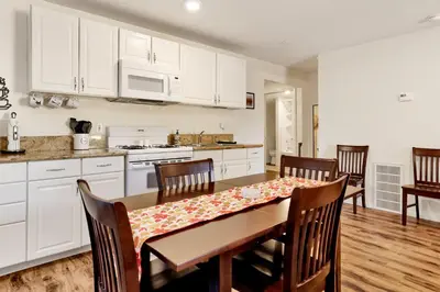 a kitchen with white cabinets and a table and chairs at The weekender #2342 in Big Bear City