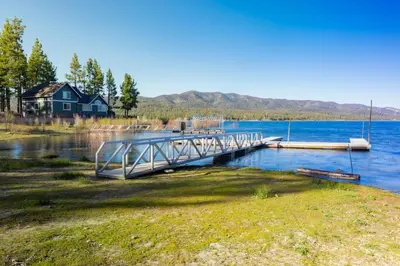 a dock on a lake with a house in the background at Lakeview #104 in Big Bear Lake