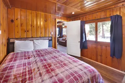 a bedroom with a bed in a wooden room at Lakeview #104 in Big Bear Lake