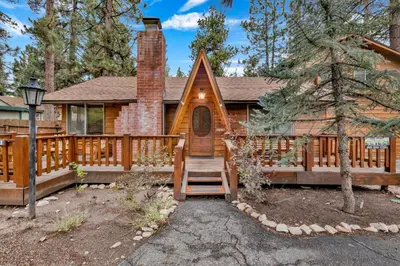 a log cabin with a staircase leading to the front door at The lost compass #2165 in Big Bear Lake