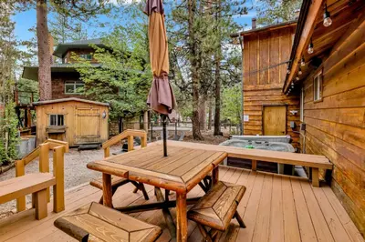 a wooden table with an umbrella on a deck at The lost compass #2165 in Big Bear Lake