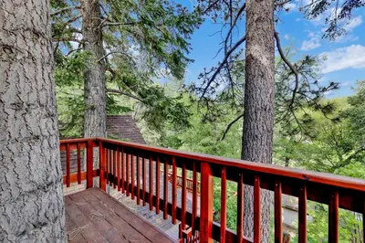 a wooden deck in the woods with trees at Knickerbocker retreat #2321 in Big Bear Lake