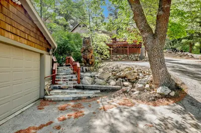 a house with a bear statue next to a driveway at Knickerbocker retreat #2321 in Big Bear Lake