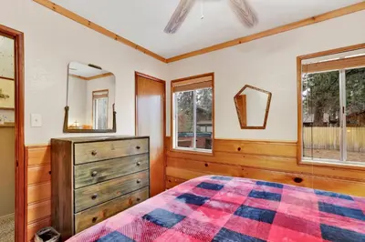 a bedroom with a bed and a dresser and windows at Timber pines chalet #2417 in Big Bear Lake