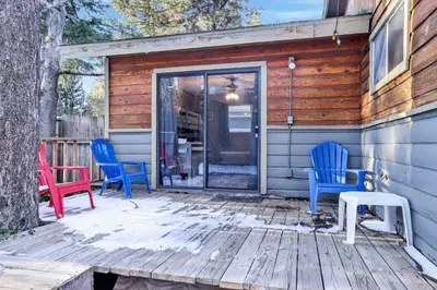 a deck with blue and red chairs on a house at Lakefront #110 in Big Bear Lake