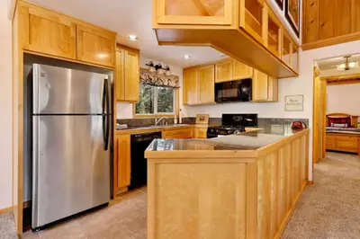 a kitchen with a stainless steel refrigerator and wooden cabinets at Moulin rouge #2055 in Big Bear Lake