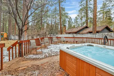 a hot tub in a yard with a fence at Flitterbick lodge #2246 in Fawnskin
