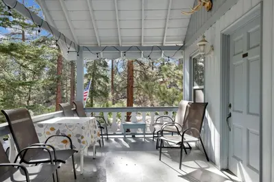 a screened porch with a table and chairs on it at Pinglewood cabin #2096 in Fawnskin