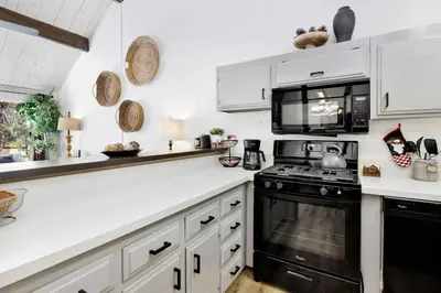 a kitchen with white cabinets and black appliances at Switzerland slopes #2125 in Big Bear Lake
