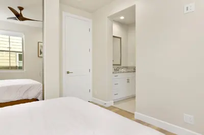 a white bedroom with a bed and a mirror at The pines retreat #2336 in Big Bear Lake