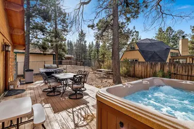 a hot tub on a deck with a table and chairs at Mountain adventure #1931 in Big Bear Lake