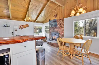 a kitchen and dining room with a table and a fireplace at Storyville #2294 in Big Bear Lake