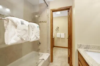 a bathroom with a tub and a shower with towels at Forest shores lake view condo #2250 in Big Bear Lake