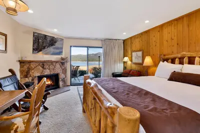 a bedroom with a large bed and a fireplace at Forest shores lake view condo #2250 in Big Bear Lake