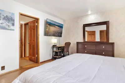 a bedroom with a bed and a desk and a mirror at The octagon #2394 in Big Bear City