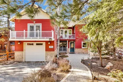a red house with a white garage at The grand chalet #1989 in Big Bear Lake