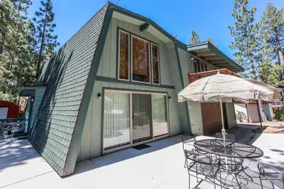 a green house with chairs and an umbrella at Switzerland ski chalet #845 in Big Bear Lake