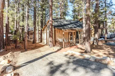 a cabin in the woods with a porch and trees at Pines 23 #1438 in Big Bear Lake