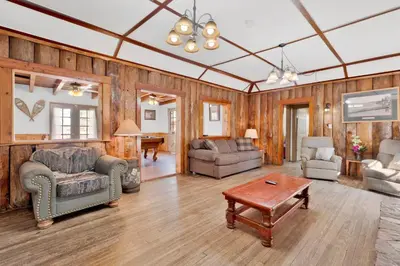 a living room with wood paneled walls and a ceiling at Lodge house #100 in Big Bear Lake
