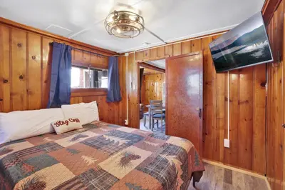 a bedroom with a bed in a room with wooden walls at Shore acres lodge #451 in Big Bear Lake