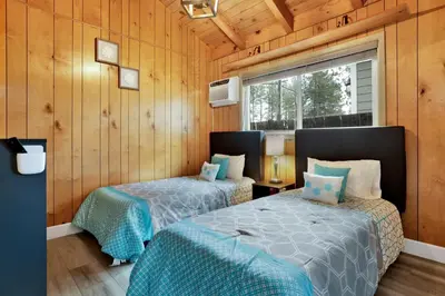 two beds in a room with wooden walls at Sweet retreat 1 #2332 in Big Bear Lake