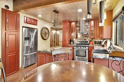 a large kitchen with red cabinets and a table at How sweet it is #1531 in Big Bear Lake