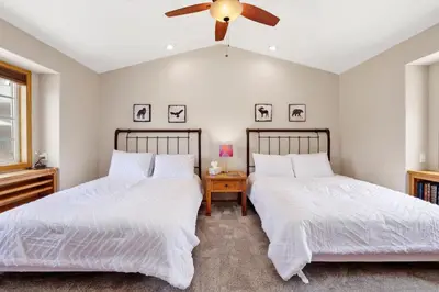 two beds in a bedroom with a ceiling fan at Lakefront village castle #2312 in Big Bear Lake